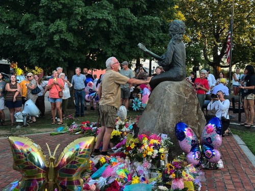 James A. Gambrell, a former chef at Dollywood, touches the Dolly Parton statue in downtown Sevierville, Tenn., on Tuesday, Aug. 25, 2026. (AP Photo/Dylan Lovan)
