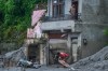 A person moves debris amid damage in the aftermath of flash floods in Devighat in the Nuwakot district in Nepal, Thursday, Aug. 27, 2026. (AP Photo/Niranjan Shrestha)