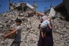 Palestinians walk amid the ruins of buildings destroyed by Israeli airstrikes during the war with Hamas, in Gaza City, Monday, Aug. 24, 2026. (AP Photo/Jehad Alshrafi)