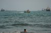A swimmer remains near the shore as a motorboat passes commercial vessels anchored in the Strait of Hormuz off Bandar Abbas, Iran, Friday, Sept. 4, 2026. (AP Photo/Vahid Salemi)