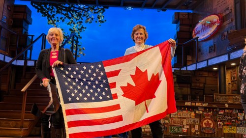 Sue Riccardelli, right, and her wife Maureen Murray are shown in this undated handout photo holding up their special Canadian and American flag after a local production of 