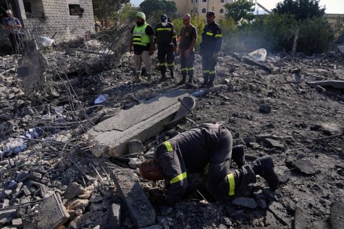 Rescue workers search for victims under the rubble of a building destroyed in an Israeli airstrike in the southern village of Kfar Rumman, Lebanon, Monday, Sept. 7, 2026. (AP Photo/Mohammed Zaatari)