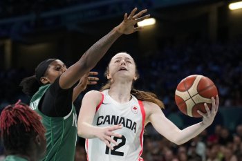 Syla Swords (12), of Canada, shoots in front of Elizabeth Balogun (4), of Nigeria, in a women's basketball game at the 2024 Summer Olympics, Sunday, Aug. 4, 2024, in Villeneuve-d'Ascq, France. (AP Photo/Mark J. Terrill)