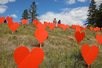 Guests look over the 104 orange hearts symbolizing children who died at the Brandon Indian Residential School during a ceremony put on by the Southern Chief's Organization and Sioux Valley Dakota Nation to honour residential school victims and survivors at the site of the former Brandon Indian Residential School, in this file photo. (Tim Smith/The Brandon Sun)