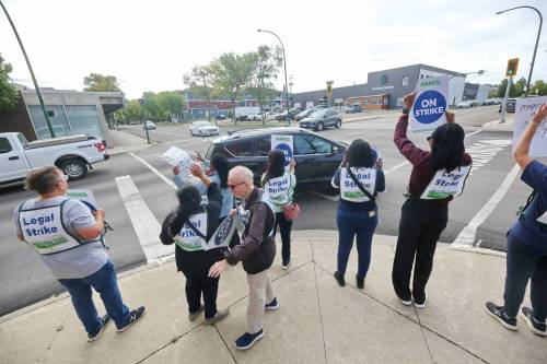 Striking Dynacare lab workers in Brandon wave to honking supporters at the busy Sixth Street and Princess Avenue intersection on Tuesday morning. They were ordered back to work after the Manitoba Labour Board halted their strike after just one day. (Matt Goerzen/The Brandon Sun)