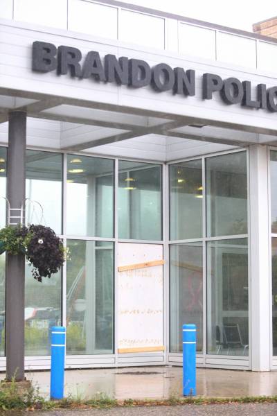 The Brandon Police Service headquarters sports a boarded-up window on its front entrance after a man wielding a sledgehammer broke it over the weekend. (Matt Goerzen/The Brandon Sun)