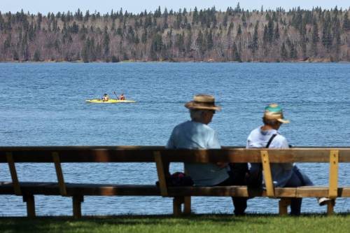 Kayakers paddle on Clear Lake in Riding Mountain National Park as other visitors sit on a bench on a sunny Monday afternoon. Nature is where Manitobans enjoy leisure time and gather with friends, but the province has no clear plan on how to protect it, Ron Thiessen writes. (Tim Smith/The Brandon Sun files)