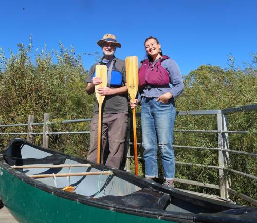 Brandon Riverbank Discovery Centre executive director Dean Hammond and community co-ordinator Ingrid Gatin stand beside a canoe on a dock that overlooks the Assiniboine River. (Rylee Gerrard/The Brandon Sun)