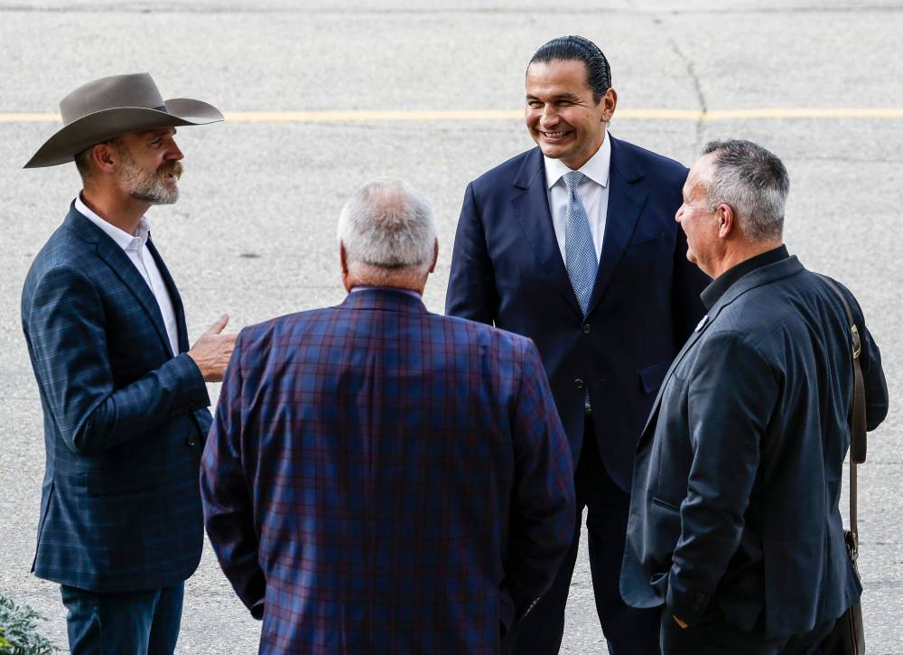 Matthew Atkinson (left), representing Manitoba Beef Producers and Canadian Cattle Association, talks with Premier Wab Kinew and Manitoba Métis Federation president David Chartrand and official Lorne Pelletier after they met with business leaders, unions and indigenous leaders to discuss trade relations with the United States at the Manitoba legislature on Aug. 24. (John Woods/Winnipeg Free Press files)