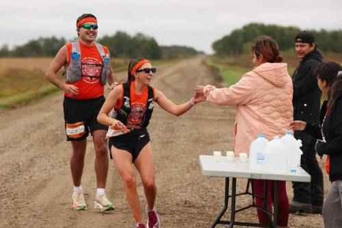 Dylan Peyachew and Reann Hucaluk of Winnipeg grab water from volunteers while taking part in the fifth annual Reconciliation Run half marathon from the former Birtle Residential School site to Birdtail Sioux First Nation on Saturday. (Photos by Tim Smith/The Brandon Sun)