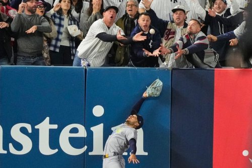 Tampa Bay Rays left fielder Victor Mesa Jr. makes an attempt on a ball interfered with by fans that umpires reviewed and ruled a run-scoring double by New York Yankees' Anthony Volpe during the sixth inning in Game 3 of baseball's American League Division Series, Wednesday, Oct. 7, 2026, in New York. (AP Photo/Yuki Iwamura)
