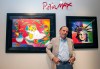 FILE - Artist Peter Max poses for a photo during his retrospective with the Road Show Company exhibit, Sept. 6, 2014, in Northbrook Court mall in Northbrook, Ill. (Photo by Barry Brecheisen/Invision/AP, File)