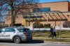 Pedestrians pass by a police car parked outside Shaarei Shomayim synagogue in Toronto, on Sunday, March 8, 2026. The synagogue was struck with gunfire overnight. THE CANADIAN PRESS/Sammy Kogan