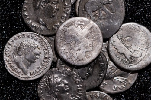 Roman coins, including the one coin, centre, dating from 148 B.C., when Rome was still a republic without an emperor, are on display at the LVR State Museum, in Bonn, Germany, Tuesday Sept. 22, 2026. (Rolf Vennenbernd/dpa via AP)