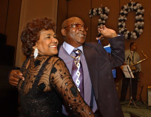 FILE - Calypso star, Slinger Francisco, otherwise known as 'The Mighty Sparrow,' right, celebrates his 70th birthday dancing calypso with Caribbean community leader Jean Alexander at a reception in his honor in the Brooklyn borough of New York, July 29, 2005. (AP Photo/Jennifer Szymaszek, File)