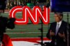 FILE - A journalist records video near a CNN sign on an athletic field outside the Clements Recreation Center where the CNN/New York Times will host the Democratic presidential primary debate at Otterbein University, Monday, Oct. 14, 2019, in Westerville, Ohio. (AP Photo/John Minchillo, File)