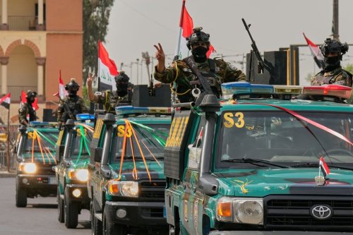 Iraqi security officers flash victory signs as they ride on vehicles decorated with national flags and ribbons during a convoy celebrating the complete withdrawal of U.S. troops from Iraq, in Baghdad, Iraq, Wednesday, Sept. 30, 2026. (AP Photo/Hadi Mizban)