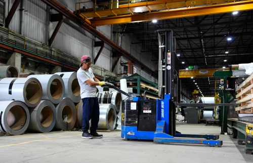 A worker operates a forklift in front of steel coils at the manufacturing plant of Ideal Roofing in Ottawa, on Tuesday, Aug. 25, 2026. THE CANADIAN PRESS/Justin Tang