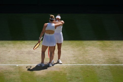 Luisa Stefani of Brazil and Gabriela Dabrowski of Canada, back to the camera, speak between points against Guo Hanyu of China and Kristina Mladenovic of France in the women's doubles final at Wimbledon Tennis Championships in London, Sunday, July 12, 2026. (AP Photo/Kirsty Wigglesworth)