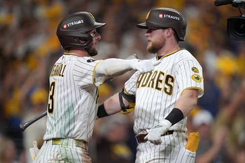 San Diego Padres' Jake Cronenworth, right, is congratulated by teammate Jackson Merrill (3) after hitting a solo home run during the fifth inning in Game 3 of baseball's National League Division Series against the Milwaukee Brewers Tuesday, Oct. 6, 2026, in San Diego. (AP Photo/Gregory Bull)
