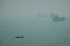 A motorboat travels past commercial vessels anchored amid haze in the Strait of Hormuz off Bandar Abbas, Iran, Monday, Sept. 7, 2026. (AP Photo/Vahid Salemi)