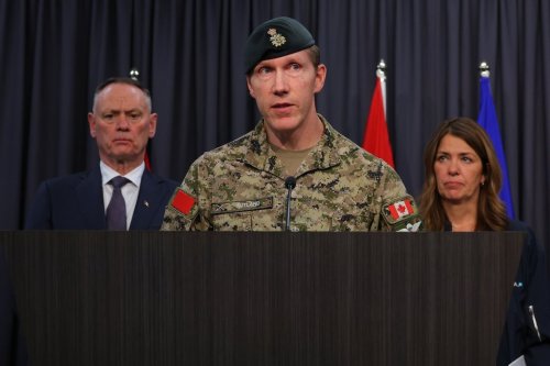 Major-General L.W. Rutland, centre, speaks as National Defence Minister David McGuinty, left, and Alberta Premier Danielle Smith, right, listen during a press conference in Edmonton, Sunday, Oct. 18, 2026. THE CANADIAN PRESS/James Maclennan