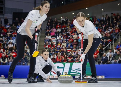 Switzerland's skip Xenia Schwaller, centre, delivers a stone against Team Canada as lead Selina Rychiger, left, and third Selina Gafner sweep during the final at the world women’s curling championship in Calgary on March 22, 2026.  THE CANADIAN PRESS/Jeff McIntosh