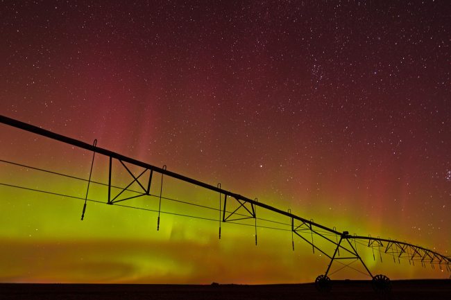 The aurora borealis lights up the sky over an irrigation pivot in a field south of Rivers late Sunday night. (Tim Smith/The Brandon Sun)