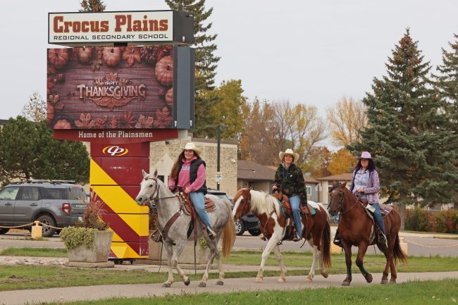Jaiden Hayward, Brooklynn Bankert and Hope Bolstad-Duncan with Acres of Hope Stables ride horses past Crocus Plains Regional Secondary School and back toward the stables after visiting Tim Hortons on Friday morning. (Tim Smith/The Brandon Sun)(Tim Smith/The Brandon Sun)