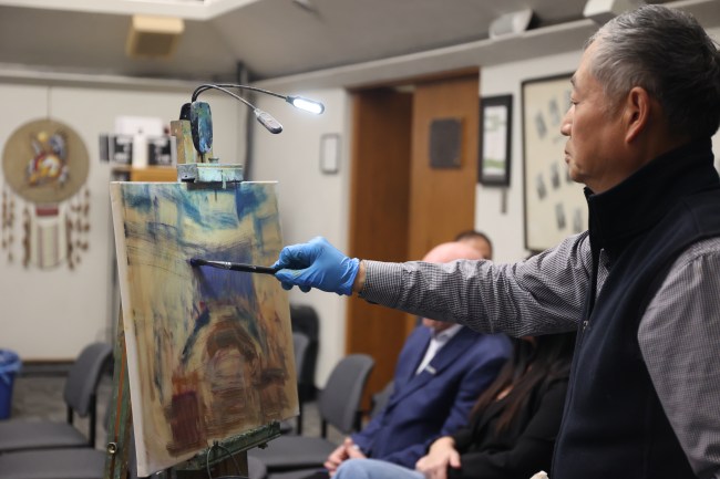 Renowned Brandon artist Weiming Zhao paints the last meeting of the 2022-26 council term at Brandon City Hall on Monday. Coun. Tyson Tame (Ward 10) said he commissioned Zhao to paint the meeting as it could be Tame's final council meeting as a councillor. The election is Oct. 28. (Alex Lambert/The Brandon Sun)