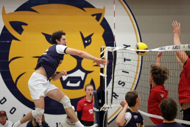 Ryden Hargreaves of the Brandon Bobcats leaps to put the ball over the net during a match against the University of Winnipeg Wesmen at the Brandon University Healthy Living Centre on Friday afternoon. (Tim Smith/The Brandon Sun)