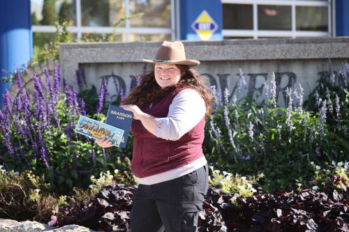 Prairie Rovers Tour founder and owner Alison Dawson holds the book 