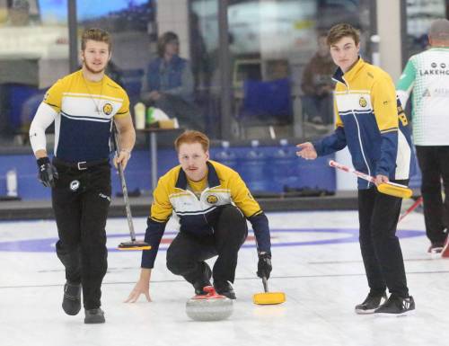 Skip Logan Strand watches as Owen McFarlane (left) and Tristan Purkess (right) follow the rock brooms in hand at the Brandon Curling Club on Wednesday. (Rowan McCarthy/The Brandon Sun)