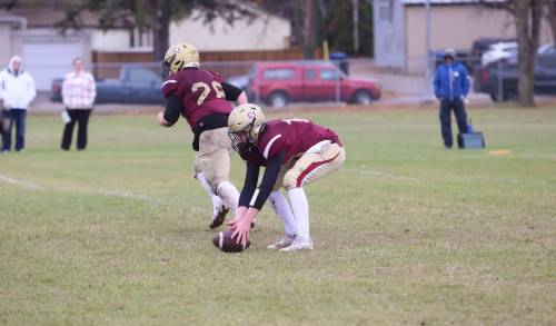 Crocus Plains quarterback Jake Cory (right) picks up a low snap off the ground at Neelin High School on Thursday. Cory and the offence struggled throughout the contest against Oak Park. (Rowan McCarthy/The Brandon Sun)