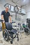 Tim Daigle, Creation Nation Makerspace co-ordinator, moves a wheelchair through the room filled with other donated medical equipment that will one day be refurbished by volunteers and resold at a discounted price. (Rylee Gerrard/The Brandon Sun)