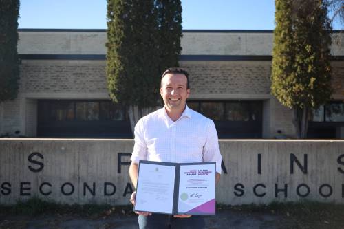 Crocus Plains Regional Secondary School physics teacher Christopher Sarkonak holds his Prime Minister's Award certificate of achievement for teaching excellence in science, technology, engineering and mathematics (STEM) in front of the high school on Monday afternoon. (Abiola Odutola/The Brandon Sun)