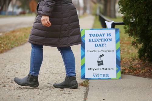 A woman walks past an election-day sign at the Brandon School Division office polling station on Sixth Street on Wednesday afternoon. (Matt Goerzen/The Brandon Sun)