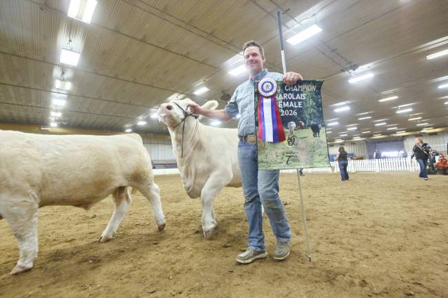 Andre Steppler from Miami proudly holds up his award for Grand Champion Charolais Female 2026 following a judged competition at the Assiniboine Credit Union Agricultural Centre on Friday afternoon. (Matt Goerzen/The Brandon Sun)