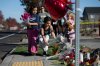 Children place flowers at a makeshift memorial outside Silver Rail Elementary in Bend, Ore., Friday, Oct. 16, 2026, a day after a deadly shooting. (AP Photo/Joe Kline)