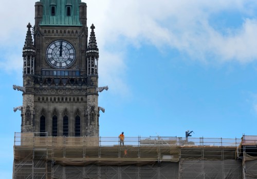 A worker stands on top of the Centre Block buildings below the Peace Tower on Parliament Hill in Ottawa on Tuesday, Sept. 8, 2026. THE CANADIAN PRESS/Adrian Wyld