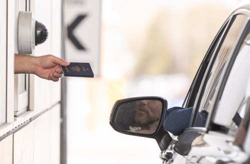 A Canada Border Services officer hands passports back to a visitor entering Canada from Vermont at the Highway 55 Port of Entry in Stanstead, Que., on Thursday, March 13, 2025. On June 11, the U.S. Department of State reissued its travel advisory for Canada, keeping a 'level one' rating, the lowest advisory level for safety and security risk. THE CANADIAN PRESS/Christinne Muschi