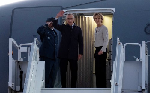 Prime Minister Mark Carney and his wife Diana Fox Carney board a government plane in Ottawa, Wednesday, Oct. 21, 2026. THE CANADIAN PRESS/Adrian Wyld
