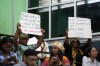FILE - People hold signs during a speech by Charles Gladstone, a descendant of former plantation owner John Gladstone, as he delivers an apology on behalf of the Gladstone family at Georgetown University in Georgetown, Guyana, Friday, Aug. 25, 2023. (AP Photo/Chris Leung, File)