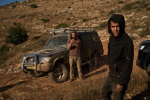 Israeli settlers block a road before Palestinians are prevented from continuing to harvest olives in the West Bank village of Deir Abu Mashal, Monday, Oct. 19, 2026. (AP Photo/Leo Correa)