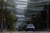 A local man rides a bicycle beneath anti-drone nets stretched over a street during a local ceasefire related to a humanitarian aid mission in Oleshky, in Kherson, Ukraine, Wednesday, Oct. 28, 2026. (AP Photo/Evgeniy Maloletka)