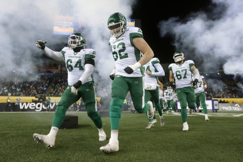 Saskatchewan Roughriders' Trevon Tate (64) and teammate Payton Collins (62) lead teammates as they run onto the field prior to first half CFL football action against the Montreal Alouettes at the 112th Grey Cup, in Winnipeg on Sunday, Nov. 16, 2025. THE CANADIAN PRESS/John Woods
