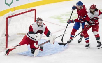 Carolina Hurricanes goaltender Brandon Bussi (32) makes a save against Montreal Canadiens' Florian Xhekaj (63) as Hurricanes' Jalen Chatfield (5) defends during third period NHL hockey action in Montreal on Tuesday, Oct. 6, 2026. THE CANADIAN PRESS/Christinne Muschi