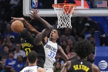 Dallas Mavericks center Jamarion Sharp (33) blocks a shot against Utah Jazz forward Taylor Hendricks (0) during the second half of a preseason NBA basketball game Thursday, Oct. 10, 2024, in Dallas. (AP Photo/LM Otero)