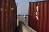 A police officer stands guard at a road barricaded with shipping containers by authorities ahead of a protest by the supporters of imprisoned former Prime Minister Imran Khan demanding his release, in Peshawar, Pakistan, Sunday, Oct. 11, 2026. (AP Photo/Mohammad Zubair)