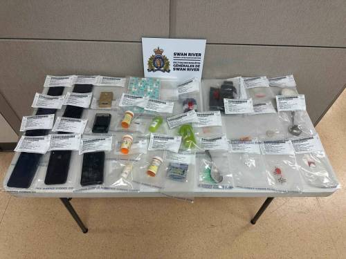A table is covered with seized evidence after 10 people were arrested and charged with drug trafficking offences following the execution of search warrants at four Swan River residences on Oct. 1-2. (Manitoba RCMP)